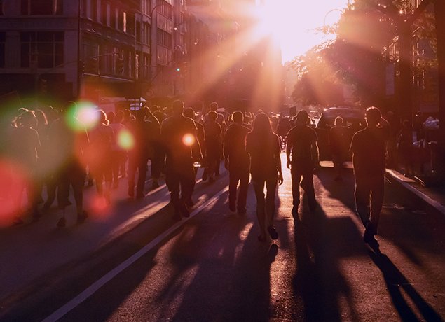 crowd walking in the street with bright sun